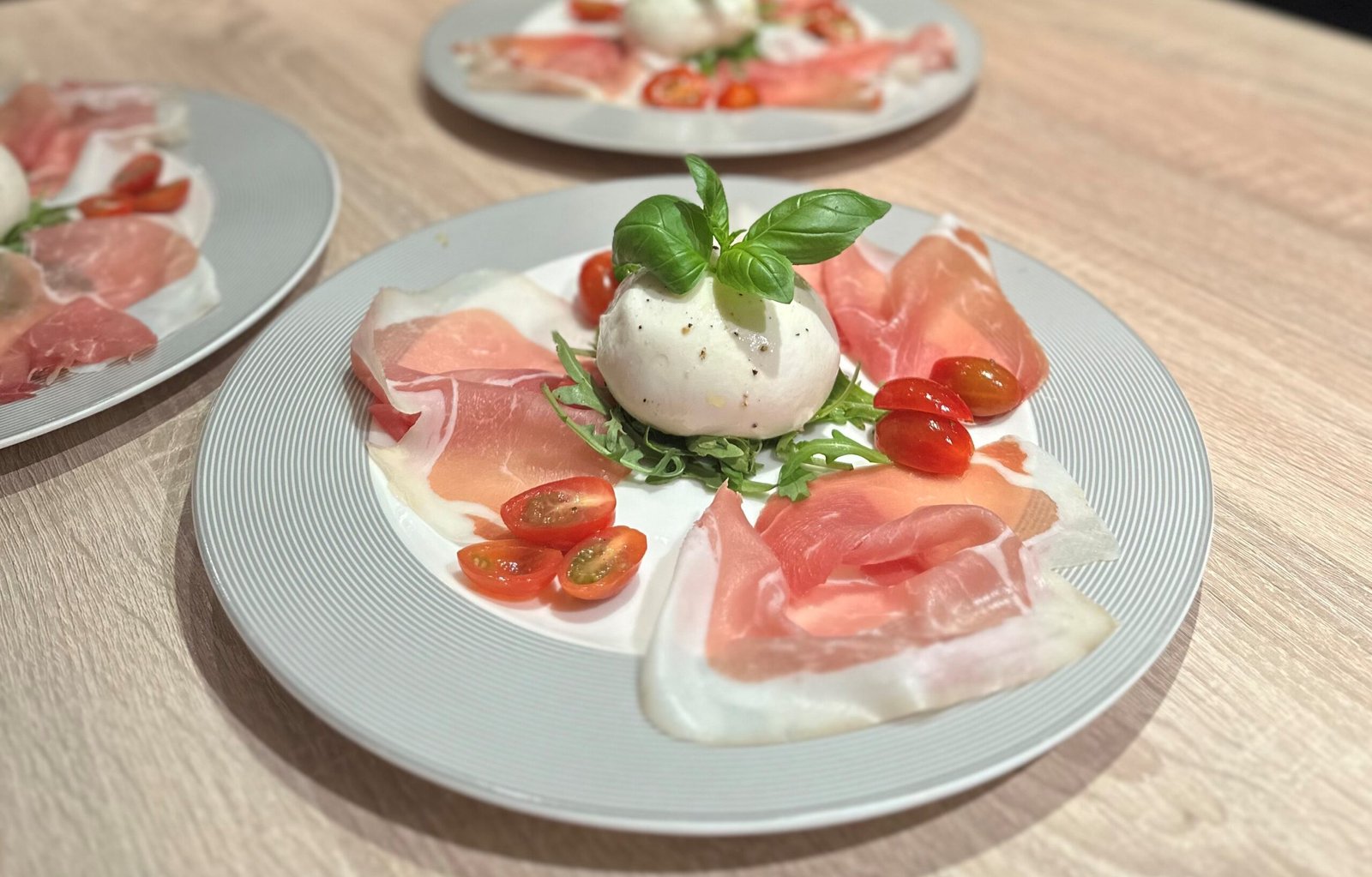 Burrata mit Parmaschinken, Rucola und Cherrytomaten